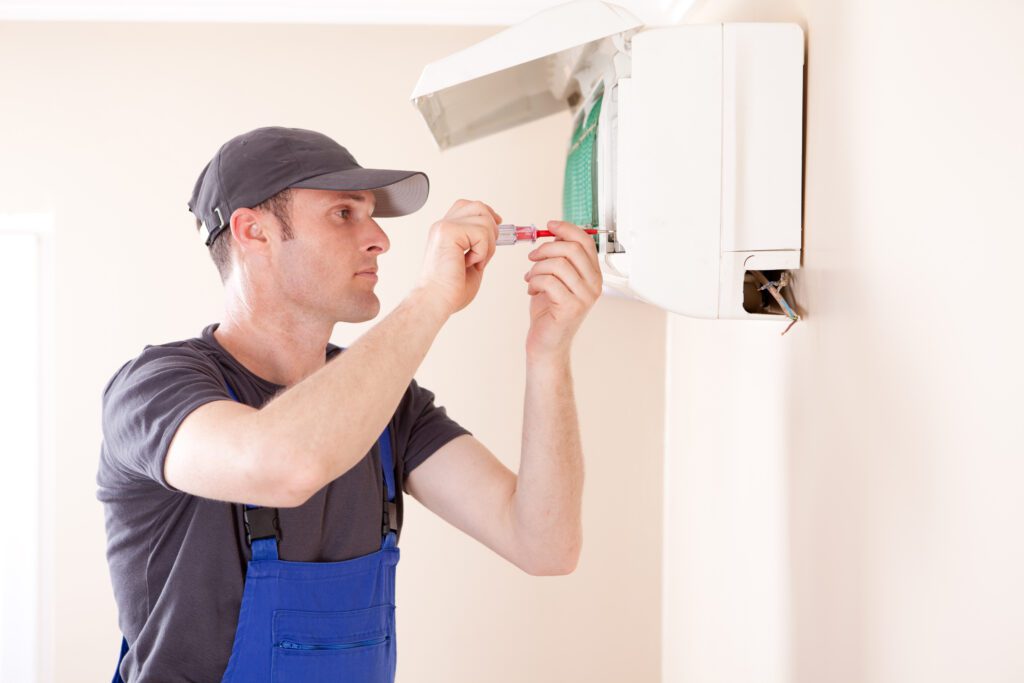 Air Conditioner Installation, Air conditioner technician servicing indoor with One Hour Air Conditioning & Heating of Prescott, AZ