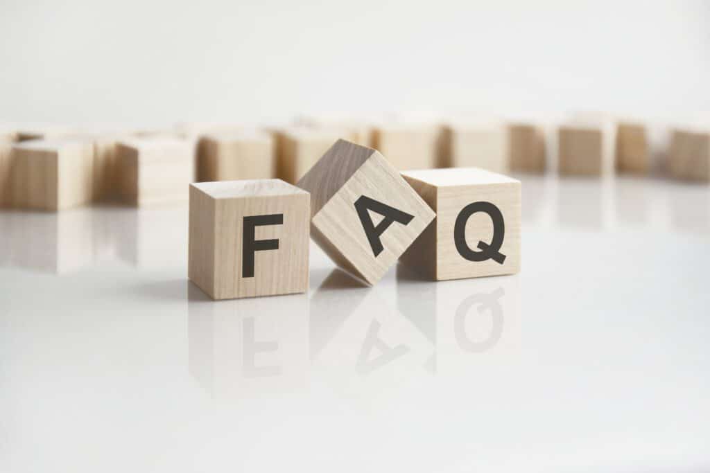 Wooden blocks with the letters 'FAQ' on a white background, with the reflection of the caption on the mirrored surface of the table. FAQs for Residential HVAC