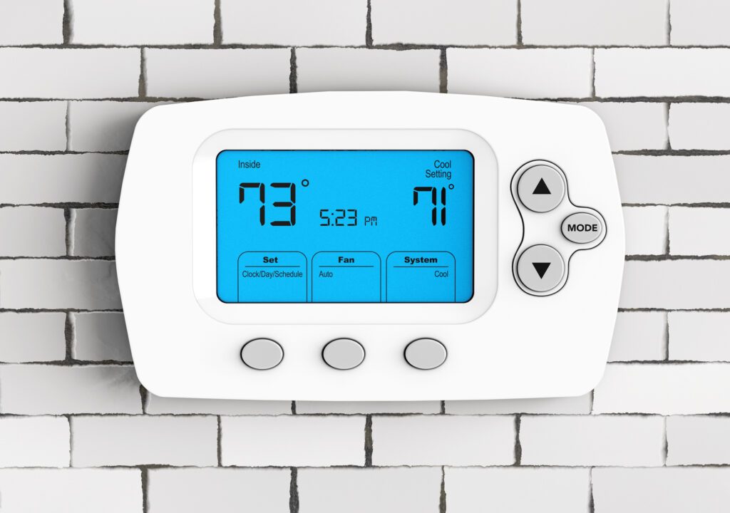 Modern Programming Thermostat in front of Brick Wall. Programmable Thermostats Installation